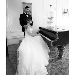 A sophisticated black and white portrait by the piano. This image showcases our ability to create elegant, classic pre-wedding pictures in an indoor setting, focusing on poise and connection.