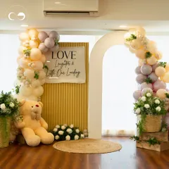 A classic teddy bear picnic is always a heartwarming choice. This full event view shows a cozy and elegant setup with a custom backdrop, pastel balloon garlands, and fresh floral arrangements, creating a perfect photo corner and a warm welcome for guests.