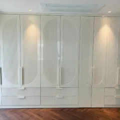 This version of our custom wardrobe features a fluted texture within the CNC-milled patterns, adding subtle detail and depth to the high-gloss PU shutters.