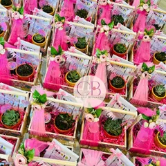 A beautiful display of our luxurious candy-themed first birthday return favours. Each pinewood basket is filled with a succulent plant and a jar of our handmade chocolates, all wrapped in pink tulle.