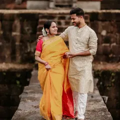 A couple dressed in beautiful traditional attire walks across an ancient stone bridge, a perfect blend of heritage and romance for a pre-wedding shoot.