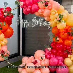 A close-up of the sunset ring arch, highlighting the neon "Happy Birthday" sign and the beautiful blend of colors.