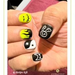A different angle of our playful graphic nail art, showing off the yin-yang symbol, bunny, and flame designs from another perspective.