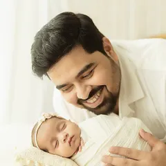 A father’s gentle gaze upon his sleeping newborn daughter. This tender moment is a perfect example of the parent-child bond I love to capture, using soft, natural light to create a warm and intimate feel.
