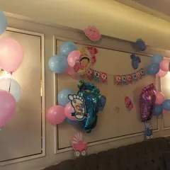 A wider view of the baby shower wall decoration, showing the placement of pink and blue balloons to match the theme.