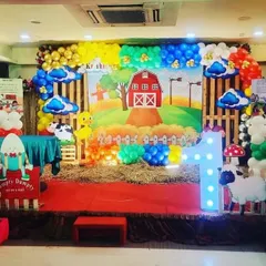 An 'Old MacDonald's Farm' theme, which is a fun variation of an animal party. The stage features a barn backdrop, hay bales, and cutouts of all the favorite farm animals like cows, pigs, and sheep.