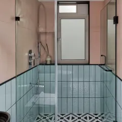 The daughters had a fun request for their bathroom: something quirky. We used patterned black and white tiles for the floor, with mint subway tiles on one wall and blush pink on the other, creating a unique and playful design.