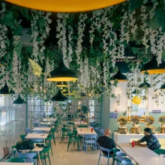 Another angle of the dining area. The combination of green and blue chairs adds a pop of color to the modern decor.