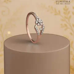 A delicate rose gold ring featuring a floral diamond cluster on a bypass shank. This piece is a beautiful symbol of everyday elegance and makes for a cherished gift.