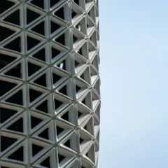A detailed close-up of VERTO's triangulated facade. The gradient in the openings is a performance-driven feature, with larger apertures at air intake and outlet points. This demonstrates how every aesthetic choice is backed by engineering logic.