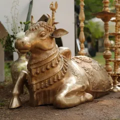 A beautifully crafted golden statue of Nandi, the sacred bull, adorned with a floral garland. This element adds a touch of divine blessing and tradition to the wedding decor.