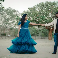 A classic pre-wedding pose in a park setting. The flowing blue gown adds a beautiful touch of elegance to this outdoor couple portrait.