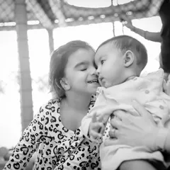 The play zone is a great place for siblings to bond and make sweet memories. This beautiful black and white photo captures a tender moment between two sisters during a birthday celebration.