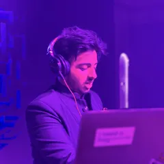 A candid shot of me focused on the mix during a set. The purple lighting adds to the mood of the party as I line up the next track.