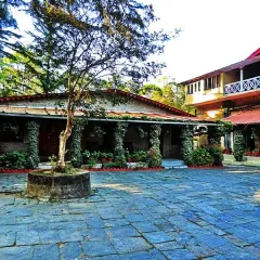The stone-paved courtyard of the hotel, surrounded by ivy-covered pillars. This space serves as a rustic and charming entry point to different parts of the property.