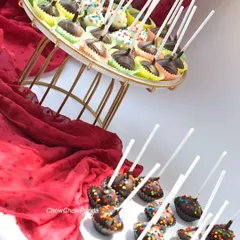 Here is a large order of cake pops ready for a party dessert table. This set includes a variety of chocolate-dipped pops, some with colourful sprinkles and others with a simple chocolate drizzle.