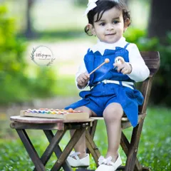 A moment to cherish forever. This sweet baby girl is playing a xylophone during her outdoor portrait session, her happy expression perfectly captured.