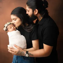 A mother's gentle kiss, a father's loving gaze. This is the story of a new family, captured in a warm, classic portrait.