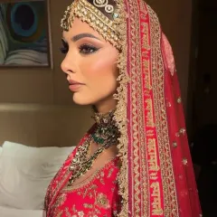 This side profile highlights the beauty of traditional head jewellery. The intricate passa and matching emerald-accented choker create a majestic look, perfect for a bride seeking timeless elegance.