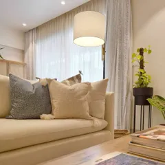 A close-up of the styling in the Breeze Home reading room. Layering pillows with different textures on a neutral sofa is a simple way to add depth and comfort to a space.