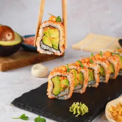 The perfect bite of an avocado sushi roll, held up by chopsticks. This shot is all about that fresh, creamy texture and is designed to be clean, modern, and super appetizing.