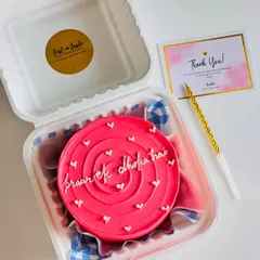 A fun and quirky bento cake with a bright pink swirl design and the message "pyaar ek dhoka hai". It's perfect for a laugh with a friend.