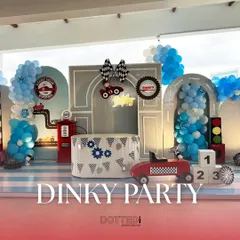 For a little one who loves cars, I created this 'Dinky Party' theme. The setup features a custom backdrop with a gas station, traffic lights, and checkered flag details, all framed by blue and white balloon garlands to get the engines started.