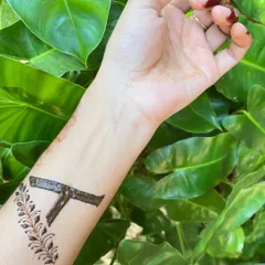 A custom design of the letter 'A' with a delicate leafy vine accent, shown with its beautiful final stain.