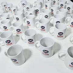 A large batch of classic white ceramic mugs, custom printed for Kotak Mutual Fund. We can produce high volumes of branded merchandise for large corporate orders.