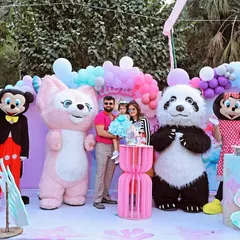 A fun family portrait from an outdoor birthday party. The celebration included character mascots like Mickey, Minnie, and a panda, creating a vibrant and exciting atmosphere for the kids.