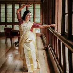 A portrait of the bride, Anjana, in a classic dance pose, showcasing the elegance of her Kerala kasavu saree. I love to incorporate elements of a bride's personality and talents into her wedding film.