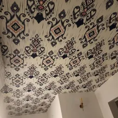 A wider view of the ceiling, showing how the wallpaper becomes a "fifth wall" of decor.