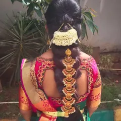 A simple and elegant bridal hairstyle featuring a traditional braid decorated with gold-plated accessories and jasmine flowers, all available for rent.