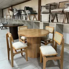 This angle highlights the pedestal base of the round dining table.