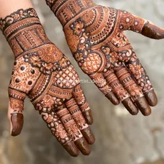 A classic full-hand bridal mehendi with fresh henna paste. You can see the crisp lines and the variety of textures, from delicate florals and paisleys to bold geometric bands and intricate check patterns.