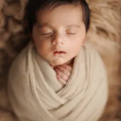 A simple, classic potato sack pose is one of my favorites. It shows off the baby's perfect little face and keeps them feeling secure and sleepy, wrapped in soft, earthy tones.