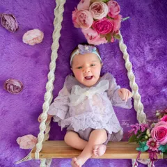 A moment of pure joy and a big, happy expression from this little one on her floral swing. It's wonderful to capture babies when they are awake and expressive too.