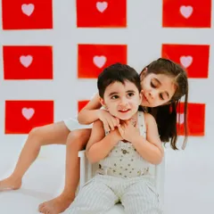 A playful hug from a big sister. This candid shot captures the mix of love and mischief that defines the sibling bond.