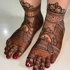 A close-up of intricate foot mehendi with detailed peacock figures. The use of negative space makes the design pop.