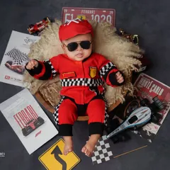 Our little racer is focused on the finish line. Even when they're asleep, we can create dynamic and fun themed shoots like this Ferrari-inspired setup, complete with racing flags and gear.