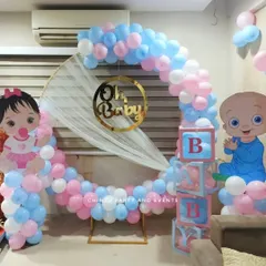 A cute 'Oh Baby' themed baby shower decoration for a home setting. The setup includes a balloon ring, character cutouts, and 'BABY' blocks.