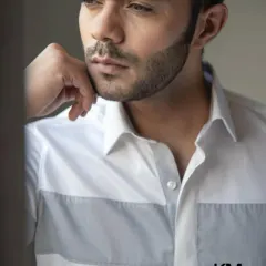 A close-up of a white shirt with a grey color-block panel. This is a modern design for a man who appreciates clean lines and a minimalist aesthetic.