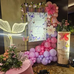 The welcome setup for Hanya's butterfly-themed first birthday. It features a beautiful sign, a cascade of pink and purple balloons, and a stunning light-up butterfly wing, setting a magical tone from the very beginning.
