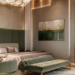 A serene bedroom where a tufted green velvet bench sits at the foot of the bed. The abstract artwork above pulls together the green and gold accents used throughout the room, creating a cohesive and artistic feel.