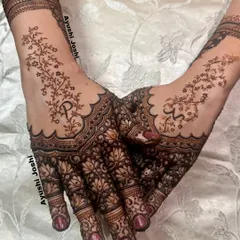 A delicate and modern design for a Roka ceremony. This mehendi features beautiful lotus patterns on the palm with a minimalist vine design on the back of the hand, including the couple's initials.