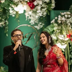 The couple enjoying their celebration against the elegant green and white backdrop. The contrast of their vibrant attire with the sophisticated decor highlights how the design serves to make the clients the center of attention.