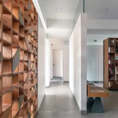 This custom-designed wooden screen is a central feature in the dental clinic. It provides visual separation and adds a warm, natural texture to the space, making the corridor feel less clinical.