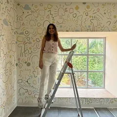 Standing on a ladder in the middle of the doodle room, adding the final touches. It felt like my own childhood dream of drawing on all the walls was coming true.