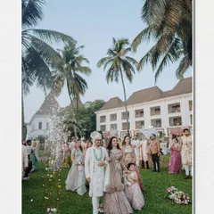 The groom makes his grand entrance with his family, set against the backdrop of a beautiful Goa resort with its iconic palm trees.