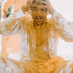 A groom getting completely covered in turmeric paste during a very enthusiastic Haldi. I love capturing the wild, messy, and joyful reality of this pre-wedding ritual.